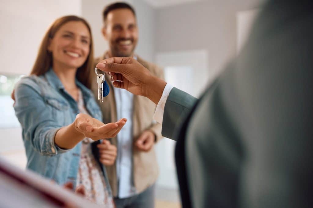 Courtier remettant les clés de sa nouvelle maison à une acheteuse